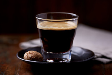 Coffee in glass cup on dark wooden background. Close up.	