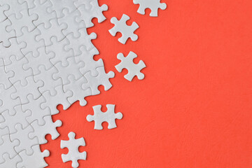 Jigsaw puzzle with white pieces isolated on a red background
