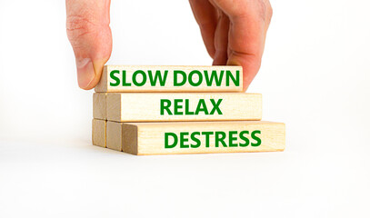 Destress symbol. Concept words Slow down Relax Destress on wooden blocks. Beautiful white table white background. Doctor hand. Psychological business slow down Relax destress concept. Copy space.