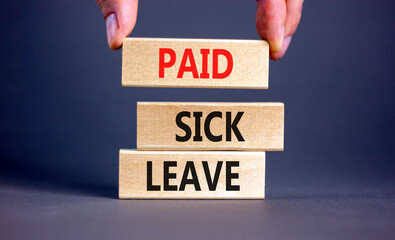 Paid sick leave symbol. Concept words Paid sick leave on wooden blocks. Doctor hand. Beautiful grey...