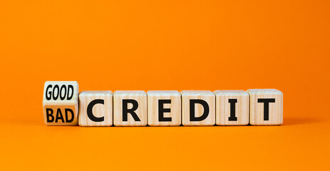 Good or bad credit symbol. Turned wooden cubes and changed concept words Bad credit to Good credit. Beautiful orange table orange background, copy space. Business good or bad credit concept.