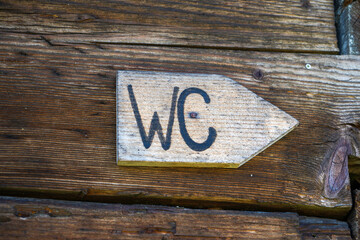 wc sign one on a wooden wall