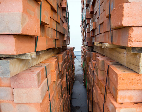 Fragment of pallets with packed red bricks