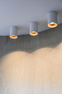 Modern glowing lamps on white ceiling