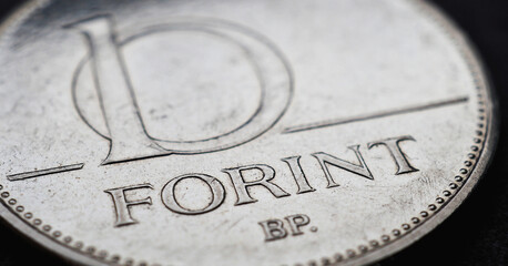 Hungarian coin of 10 forints lies on a dark black surface close-up. Money of Hungary. News about economy or finance. Loan and credit. Savings and interest. Magyar forint. Horizontal stories. Macro