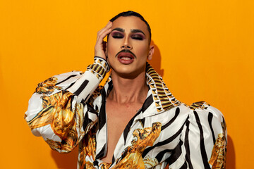 Portrait of drag queen with fashionable mustache yellow background