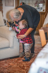 Grandmother playing with her grandson in the house living room.