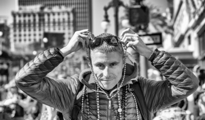 Happy smiling man wearing beads in Mardi Gras Carnival Parade, New Orleans.