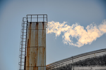 Factory chimney against the blue sky