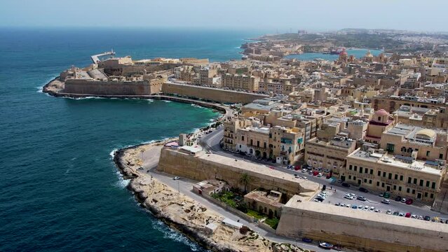 Aerial 4K footage of a drone flight over of Basilica Lady of Mount Carmel church, St. Paul's Cathedral in the old town of Valetta, Malta. Roofs of Malta capital from above on a sunny day