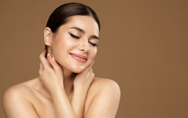 Skin Care. Beauty Face. Happy Woman enjoying Facelift Spa Massage. Model with Closed Eyes touching Fresh Clean Skin. Women Facial Cosmetology and Natural Makeup Cosmetics over beige background - obrazy, fototapety, plakaty