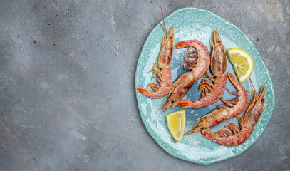 Obraz na płótnie Canvas Seafood. Red Argentine shrimps with salt and lemon, Wild shrimps, ocean jumbo shrimps on blue plate. banner, menu, recipe place for text, top view