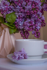 cup of coffee, lilac flower in the apartment