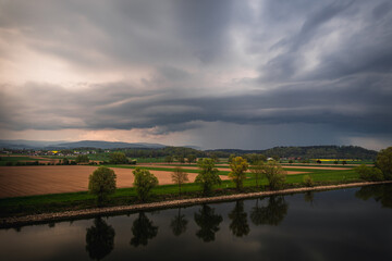 Fototapeta na wymiar Dark storm clouds in the evening sky at the Danube in Bavaria, Germany