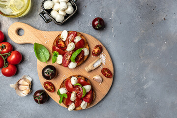 Open sandwiches with cherry tomatoes, mini mozzarella, fresh basil leaves, caprese on bread, Traditional italian appetizer or snack, antipasto. banner, menu, recipe place for text, top view