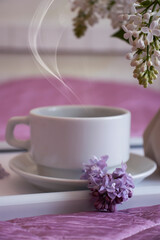 cup of coffee, lilac flower in the apartment