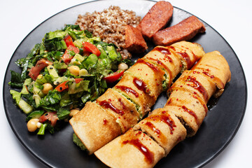 Vegan food. Baked rolls with tofu and mushrooms, seitan sausage and salad.