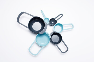 Photo of a set of plastic measuring cups of different sizes, kitchen tools.
