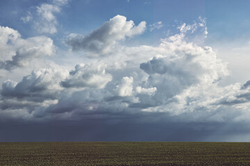 Dark rainy clouds over the field as a background or backdrop