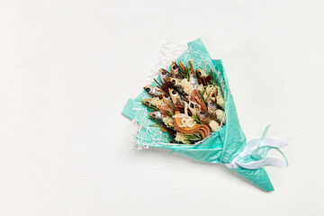Turquoise bouquet made of dried fish and snacks on a white background