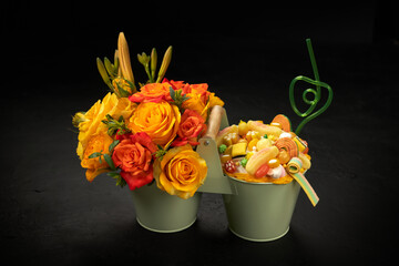 Decorative metal buckets filled with orange flowers and sweet candies of various shapes