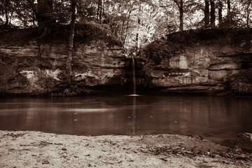 Small water pond with waterfall in sepia toning