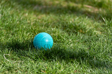 Plastic ball on green grass. Fun outdoors. A plastic ball for a child to play. Spring fresh green grass.
