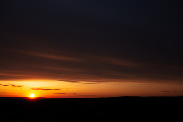 Natural landscape of colourful sunset with dark clouds.