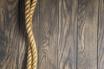 Marine rope on old oak wooden board background