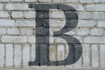 Black letter B painted to brick wall on gray background  (from a letter set containing B, C, D, F,...