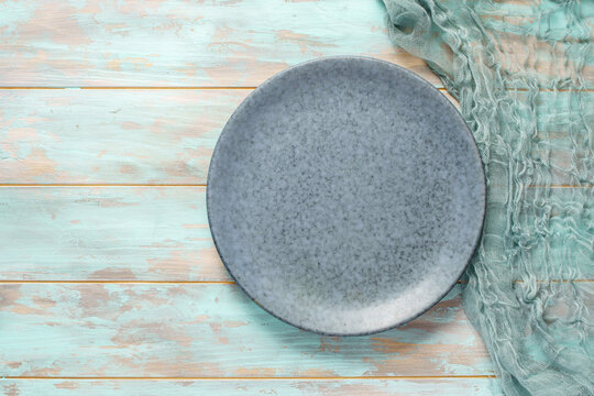 Empty bluish plate with gauze on old wooden background. Top view, with copy space