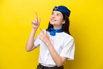 Airplane stewardess Russian woman isolated on yellow background pointing with the index finger a great idea