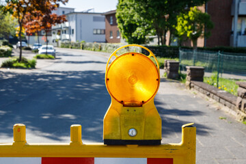 Fototapeta premium Road works. Red and white striped road caution sign with yellow flasher