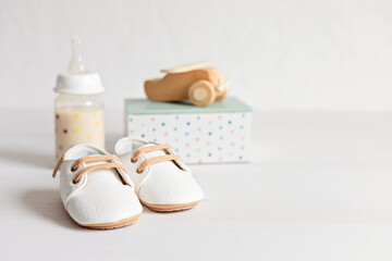 Fototapeta na wymiar Baby shoes and qccessories. Organic newborn fashion, branding, small business idea. Baby shower invitation, greeting card