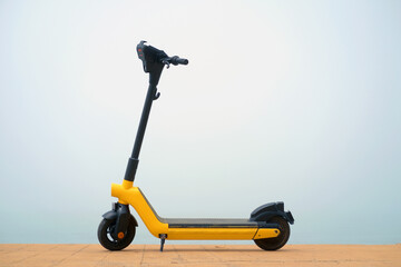 Yellow electric scooter on a misty background © Luka