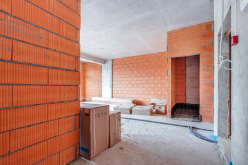 Unfinished building interior, red orange bricks room with boxes. Repairs in the apartment. Renovation preparing in the room.