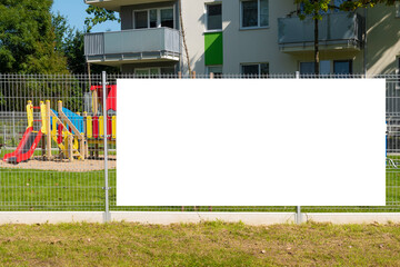 Blank white billboard for advertisement on the fence of kids playground in the city