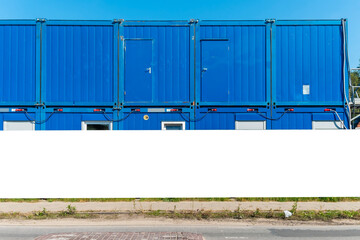 Advertising banner mock-up on the fence of construction site in front of blue construction barracks © diesirae
