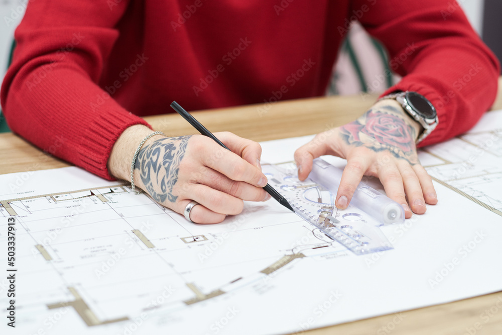 Aufkleber Close-up of architect drawing blueprint with pencil and ruler at table