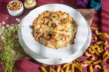 chicken cheese Cashew nuts pasta in a plate side view on wooden background