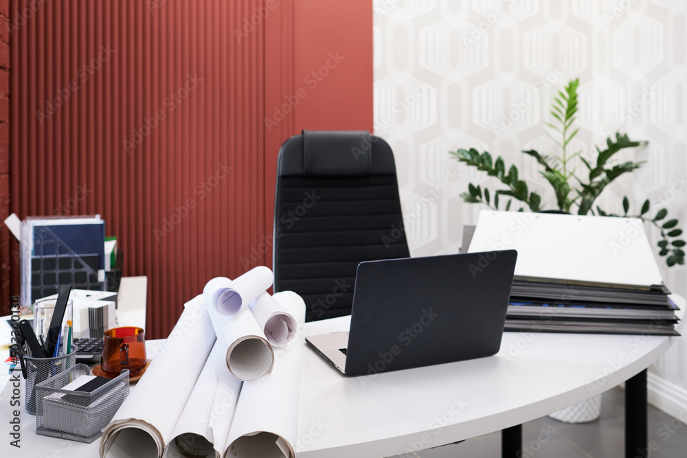 Poster workplace of architect with laptop, folders and blueprints on table at modern office