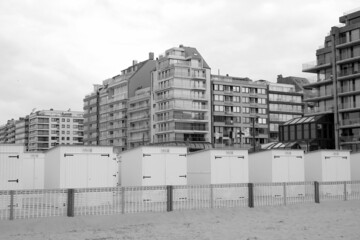 Weiße Strandkabinen vor modernen Hochhäusern am Strand von Knokke-Heist an der Nordsee bei...