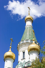 Fototapeta na wymiar Christian (Orthodox Church) domes against the blue sky. Golden cupola. Postcard. Vertical plane