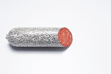 Close-up of half piece of smoked vegan sausage on white background.