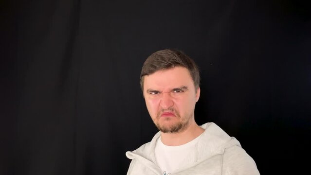 Front view of man expressing emotion of disgust, detestation, revulsion, nausea