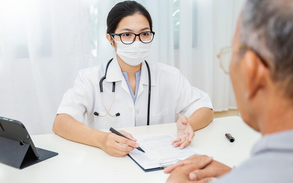 Portrait of asian woman doctor wear protection face mask showing a patient some information on digital tablet clip board, patient listen to specialist doctor in clinic office, medical protect banner