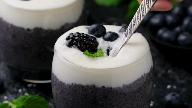 Eating Healthy vanilla blueberry chia pudding in a glass with fresh berries