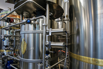 Stainless steel brewing tanks and equipment, iron reservoirs and pipes in modern beer factory. Brewery