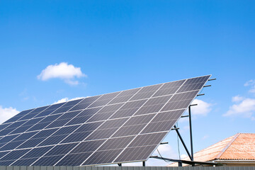 view of new modern residential house cottage with blue shiny solar photo voltaic panels system on roof. Renewable ecological eco green energy production concept