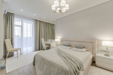 Large grey bedroom with decorated bed and bright furniture in a modern style with lights on